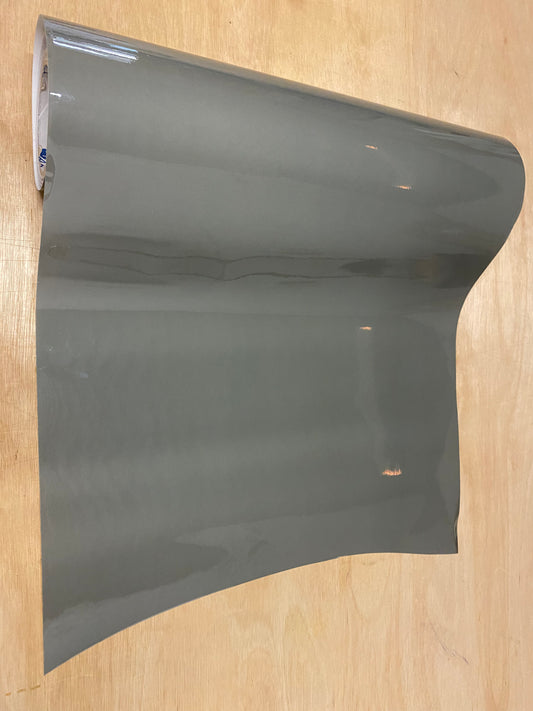 A roll of light tint film for vehicle tail lights placed on a wooden surface.